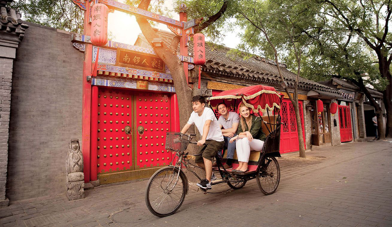 Driver and passengers in a cycle rikshaw.